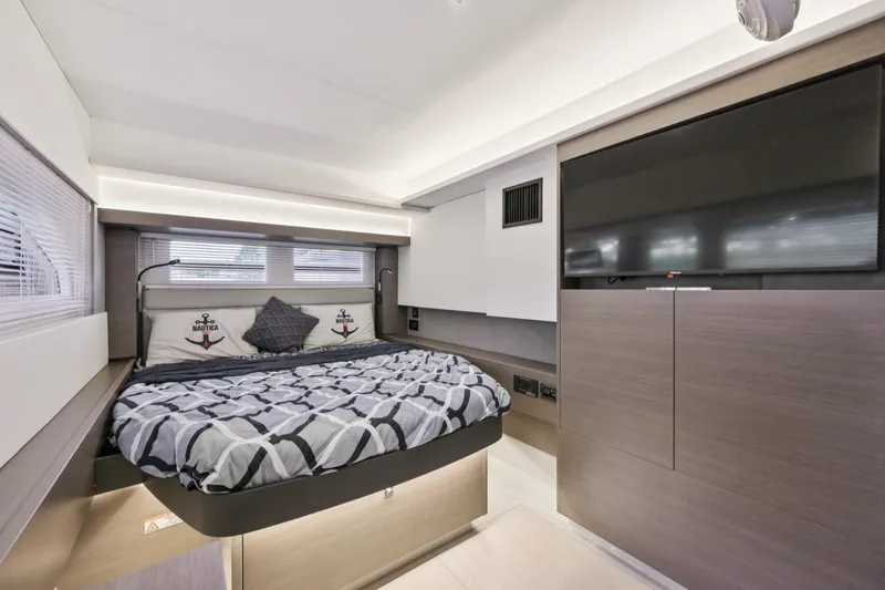 Freedom Yacht Photos Pics Luxurious bedroom interior of 2022 Leopard 53 Powercat yacht with modern decor and large TV.