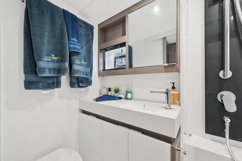 Freedom Yacht Photos Pics Modern bathroom in 2022 Leopard 53 Powercat yacht with sleek fixtures and blue towels.