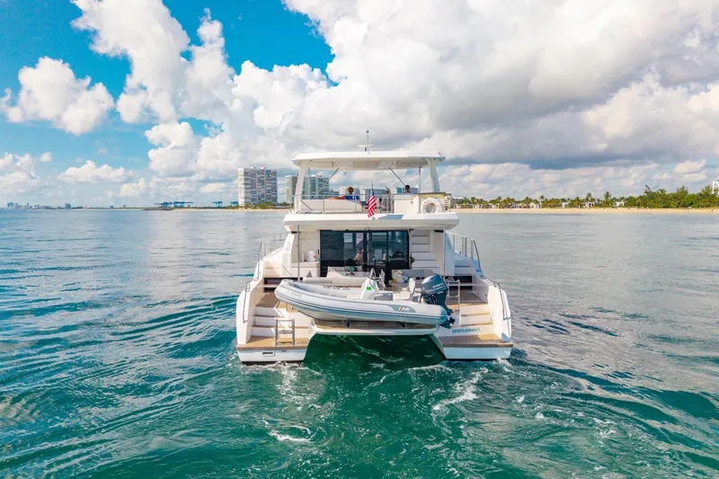 Freedom Yacht Photos Pics 2022 Leopard 53 Powercat yacht on open water, clear sky, coastal background.
