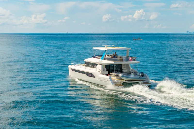 Freedom Yacht Photos Pics 2022 Leopard 53 Powercat cruising on open sea under clear blue sky.