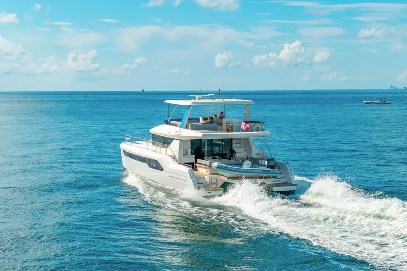 Freedom Yacht Photos Pics 2022 Leopard 53 Powercat cruising on open sea under clear blue sky.