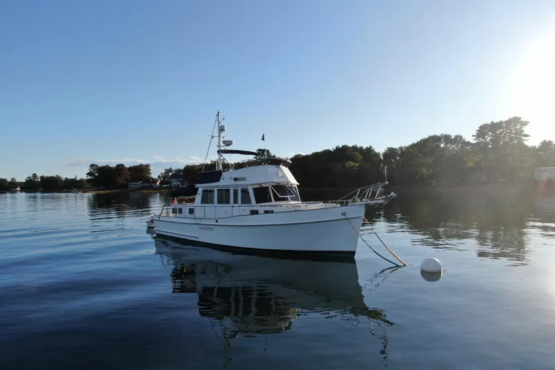 Maximon Yacht Photos Pics 1989 Grand Banks 46 yacht anchored on calm water with scenic background.
