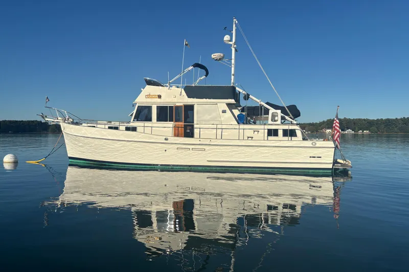 Maximon Yacht Photos Pics 1989 Grand Banks 46 yacht on calm water, reflecting clear blue sky.