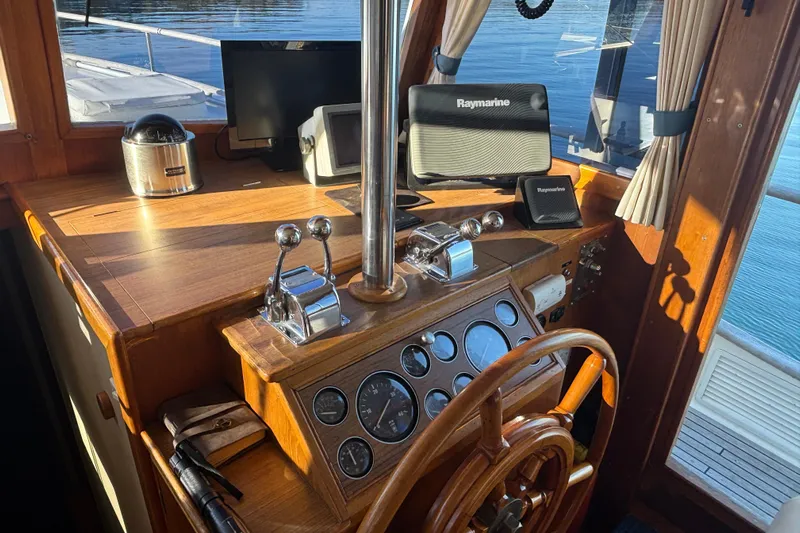 Maximon Yacht Photos Pics Helm of 1989 Grand Banks 46 yacht with Raymarine navigation equipment and wooden steering wheel.