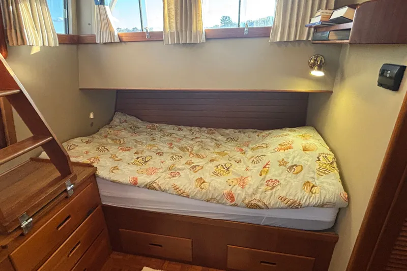 Maximon Yacht Photos Pics Cozy cabin bedroom in 1989 Grand Banks 46 yacht with nautical-themed bedding.