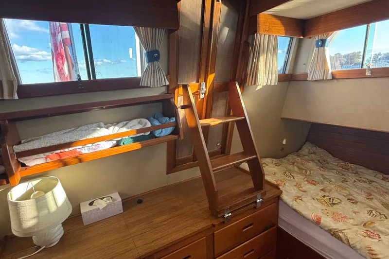 Maximon Yacht Photos Pics Cozy cabin interior of 1989 Grand Banks 46 yacht with wooden furnishings and bedding.