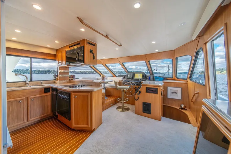 Odisea Yacht Photos Pics Luxurious 1995 Tollycraft 57 Walk Around Pilothouse interior with modern kitchen and helm.