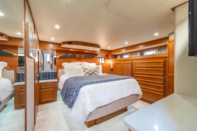 Odisea Yacht Photos Pics Luxurious bedroom interior of 1995 Tollycraft 57 Walk Around Pilothouse yacht with elegant wood finish.