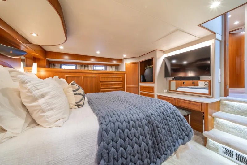 Odisea Yacht Photos Pics Luxurious bedroom in 1995 Tollycraft 57 Walk Around Pilothouse yacht, featuring elegant wood finishes.
