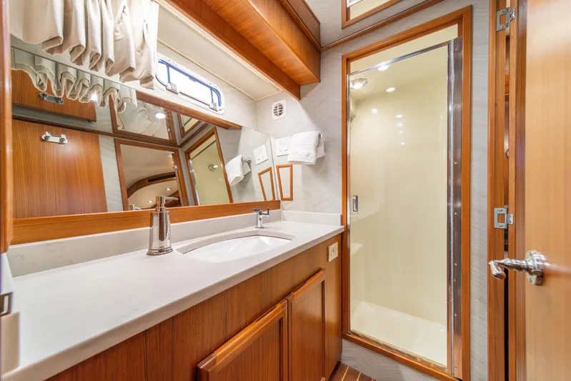 Odisea Yacht Photos Pics Luxurious bathroom in 1995 Tollycraft 57 Walk Around Pilothouse yacht, featuring wood accents and modern fixtures.