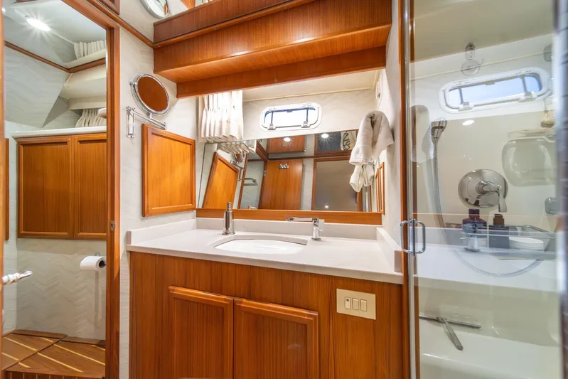 Odisea Yacht Photos Pics Luxurious bathroom in 1995 Tollycraft 57 Walk Around Pilothouse yacht, featuring wood cabinetry and modern fixtures.