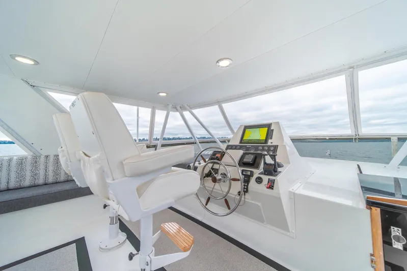 Odisea Yacht Photos Pics 1995 Tollycraft 57 Walk Around Pilothouse helm with modern navigation equipment and comfortable seating.