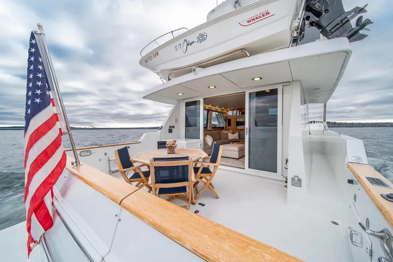 Odisea Yacht Photos Pics 1995 Tollycraft 57 Walk Around Pilothouse yacht with American flag, outdoor seating, and ocean view.