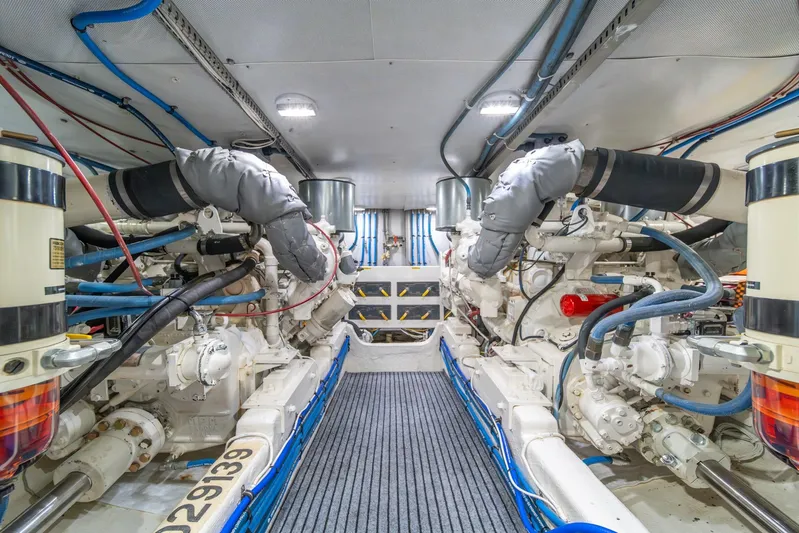 Odisea Yacht Photos Pics Engine room of 1995 Tollycraft 57 Walk Around Pilothouse, showcasing dual engines and piping.