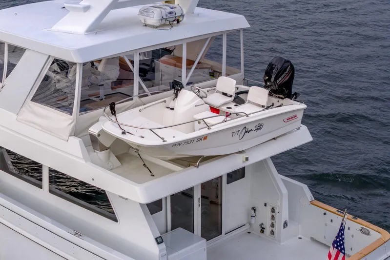 Odisea Yacht Photos Pics 1995 Tollycraft 57 Walk Around Pilothouse with a small boat on deck, ocean backdrop.