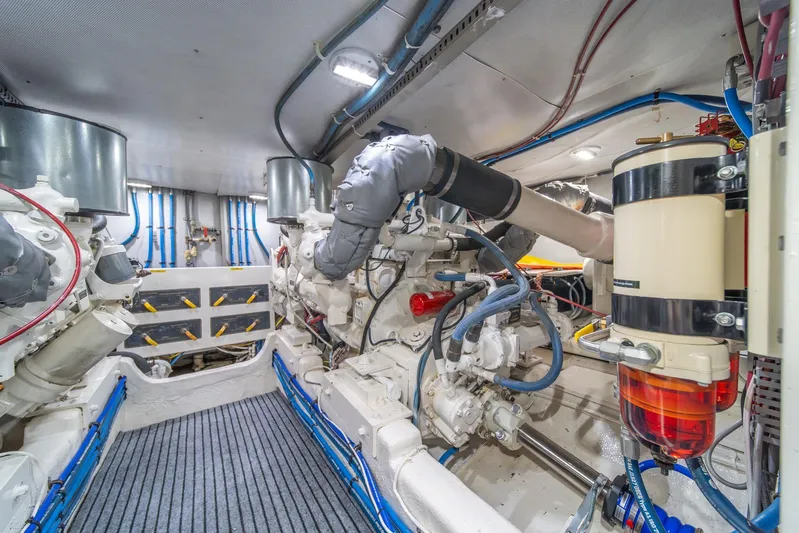 Odisea Yacht Photos Pics Engine room of 1995 Tollycraft 57 Walk Around Pilothouse, showcasing mechanical components and piping.