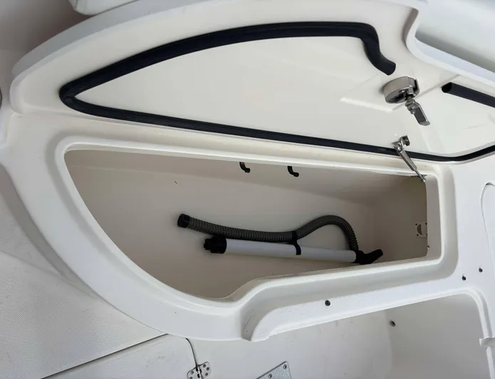  Yacht Photos Pics Storage compartment on a 2012 Edgewater 318CC boat with a hose inside.