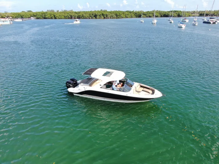  Yacht Photos Pics 2018 Sea Ray 310 SLX boat cruising on a serene lake with other boats nearby.
