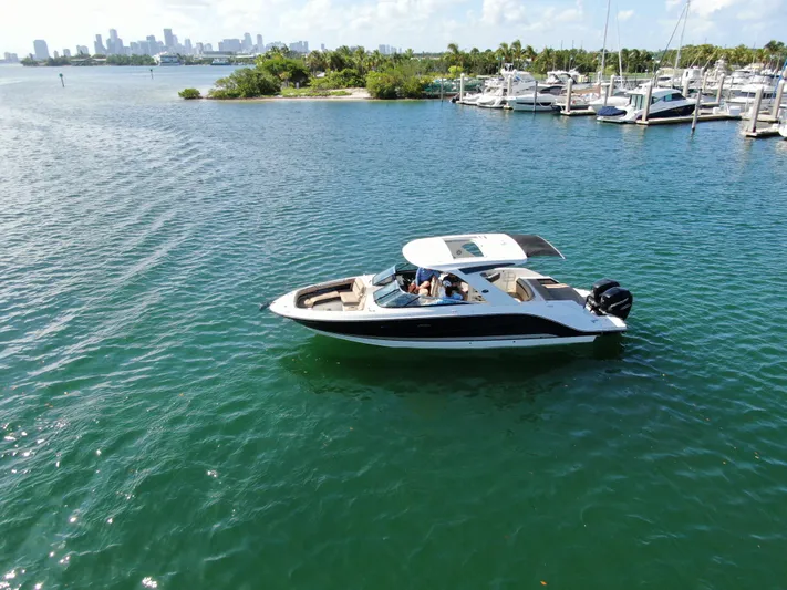  Yacht Photos Pics 2018 Sea Ray 310 SLX boat cruising on a scenic waterfront with marina backdrop.