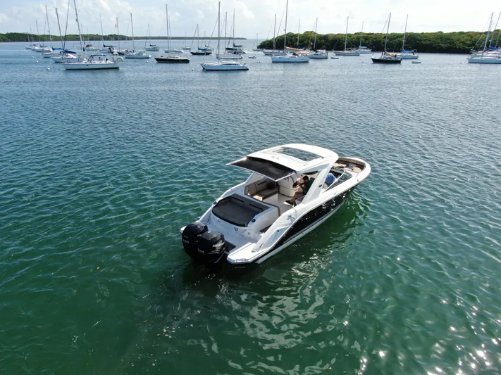  Yacht Photos Pics 2018 Sea Ray 310 SLX boat on calm water with sailboats in the background.