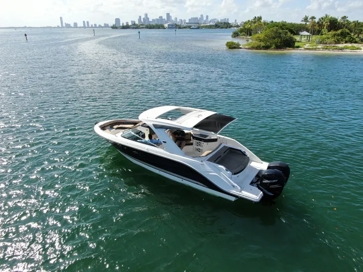  Yacht Photos Pics 2018 Sea Ray 310 SLX boat cruising on a sunny day near a city skyline.