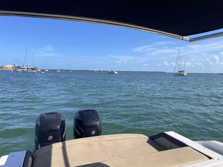  Yacht Photos Pics 2018 Sea Ray 310 SLX boat on water, view of ocean and distant sailboats.