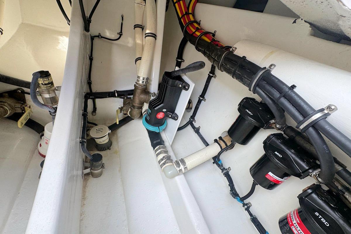 Engine compartment of a 2016 Nor-Tech 340 Sport Center Console boat, showing hoses and fittings.