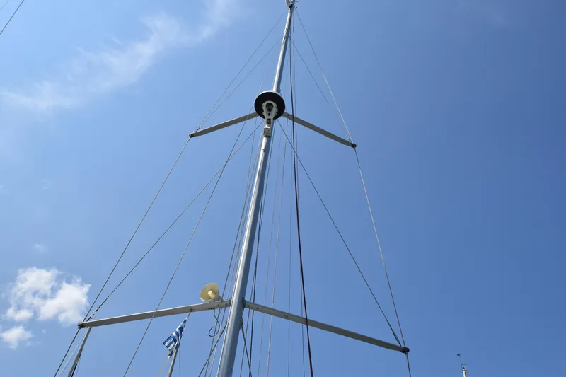 Blueconomy Yacht Photos Pics Mast of 2020 Jeanneau Sun Odyssey 490 sailboat against clear blue sky.