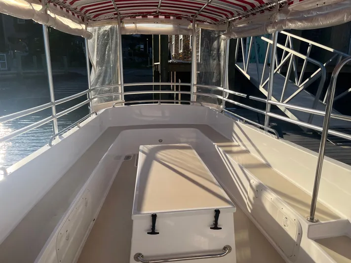 Joseph Packer Yacht Photos Pics 2024 Duffy 26 Water Taxi interior with striped canopy and seating, docked in sunlight.