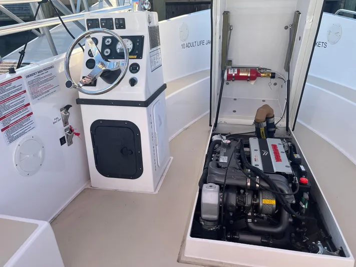Joseph Packer Yacht Photos Pics 2024 Duffy 26 Water Taxi interior showing steering console and engine compartment.