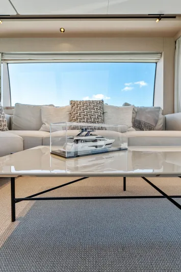 Open Sea Yacht Photos Pics Luxurious Ferretti Yachts 780 interior, 2023 model, featuring elegant seating and a yacht model display.