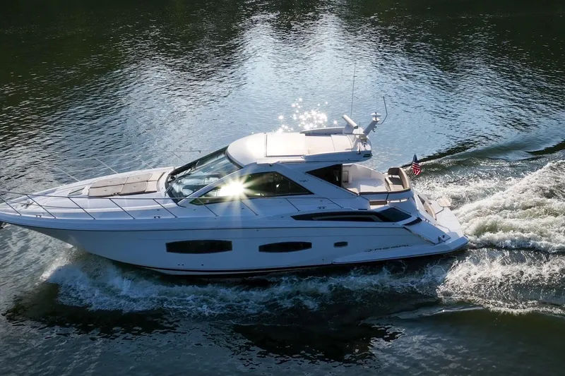  Yacht Photos Pics 2015 Regal 53 Sport Coupe cruising on a sunlit waterway.