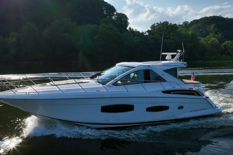  Yacht Photos Pics 2015 Regal 53 Sport Coupe cruising on a scenic waterway with lush greenery.
