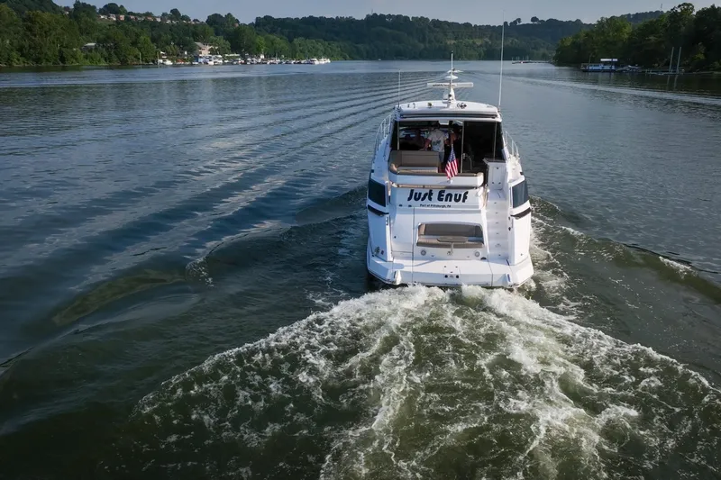  Yacht Photos Pics 2015 Regal 53 Sport Coupe cruising on a scenic river, rear view.