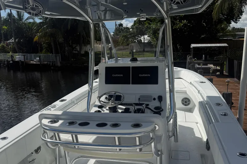  Yacht Photos Pics 2023 Contender 30 Tournament boat with Garmin navigation, docked by a lush waterfront.