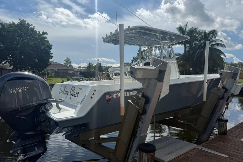  Yacht Photos Pics 2023 Contender 30 Tournament boat on lift, featuring Yamaha engine, docked by palm trees.