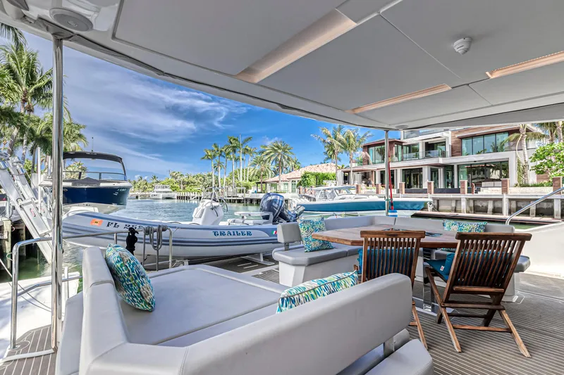 Double Feature Yacht Photos Pics Luxurious 2023 Leopard 53 Powercat yacht with elegant seating, docked near waterfront homes.