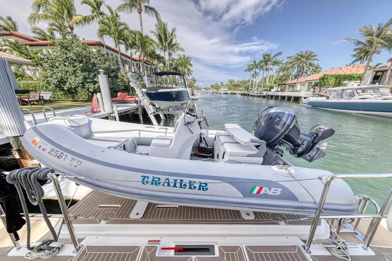 Double Feature Yacht Photos Pics 2023 Leopard 53 Powercat docked with inflatable boat, tropical waterfront setting.