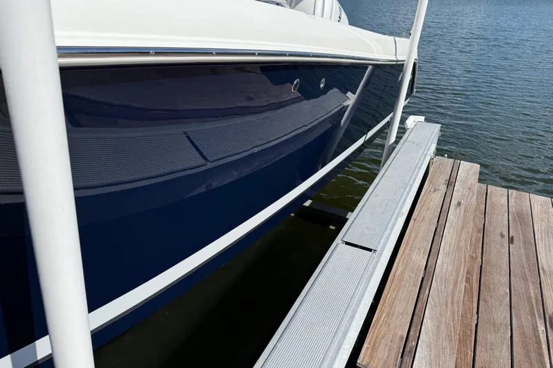  Yacht Photos Pics 2024 Pursuit S 248 Sport boat docked on calm water, showcasing sleek design.