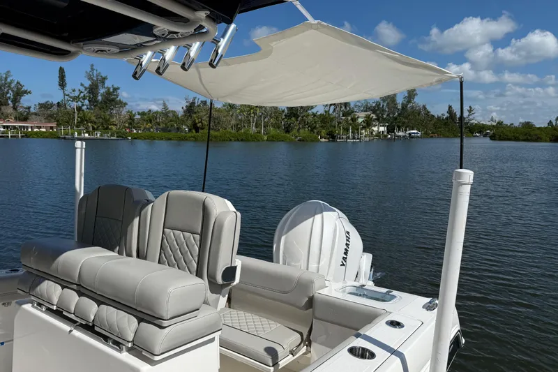  Yacht Photos Pics 2024 Pursuit S 248 Sport boat with seating and canopy on a serene lake.