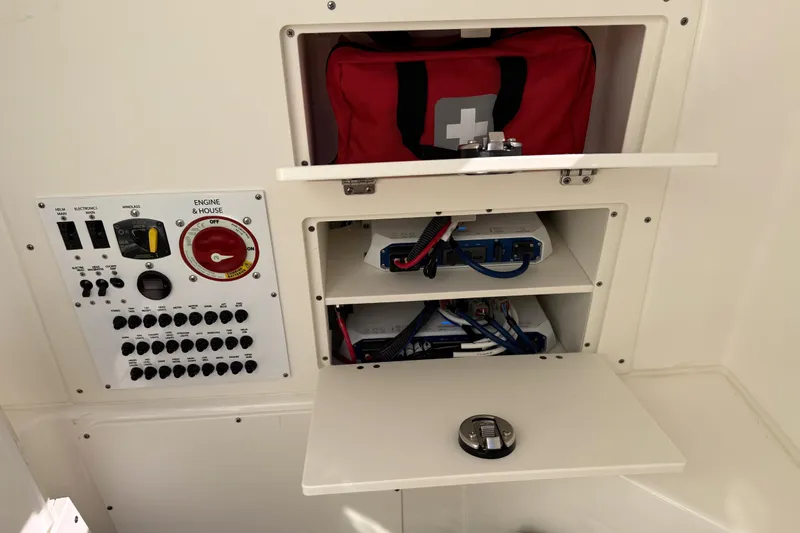  Yacht Photos Pics 2024 Pursuit S 248 Sport boat electrical panel and storage compartments with safety equipment.