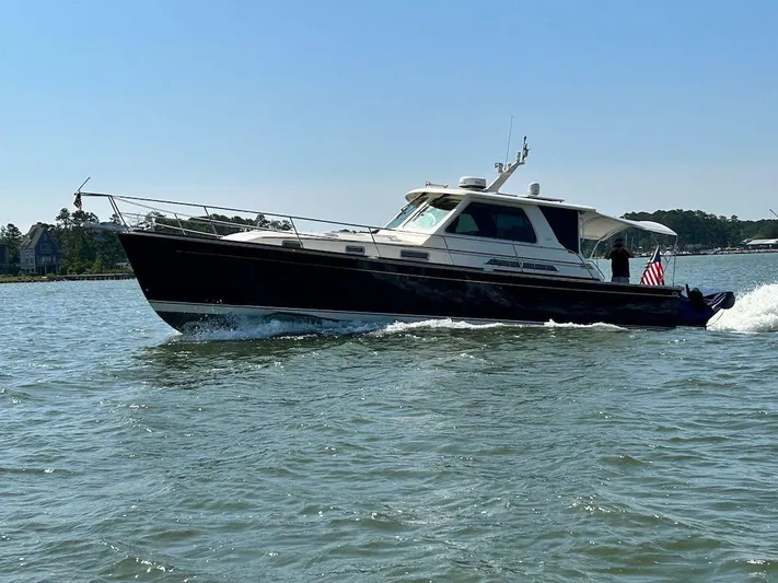 Dawn Treader Yacht Photos Pics 2008 Sabre 42 Hard Top Express cruising on a sunny day, American flag displayed.