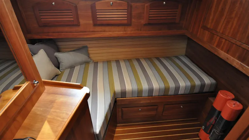 Dawn Treader Yacht Photos Pics Cozy cabin interior of 2008 Sabre 42 Hard Top Express with striped bedding and wooden finish.