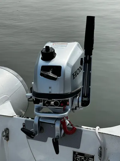 Dawn Treader Yacht Photos Pics Outboard motor on a 2008 Sabre 42 Hard Top Express boat, docked on calm water.