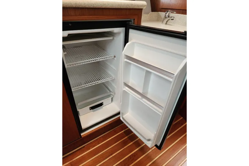  Yacht Photos Pics Open refrigerator in 2001 Tiara Yachts 3500 Open, showcasing interior shelves and door storage.