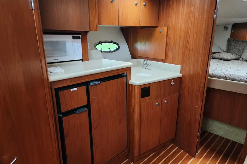  Yacht Photos Pics 2001 Tiara Yachts 3500 Open interior with kitchenette, microwave, and wood cabinetry.
