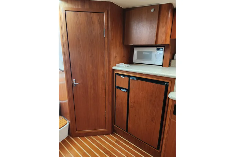  Yacht Photos Pics 2001 Tiara Yachts 3500 Open interior with wood cabinetry, microwave, and compact fridge.