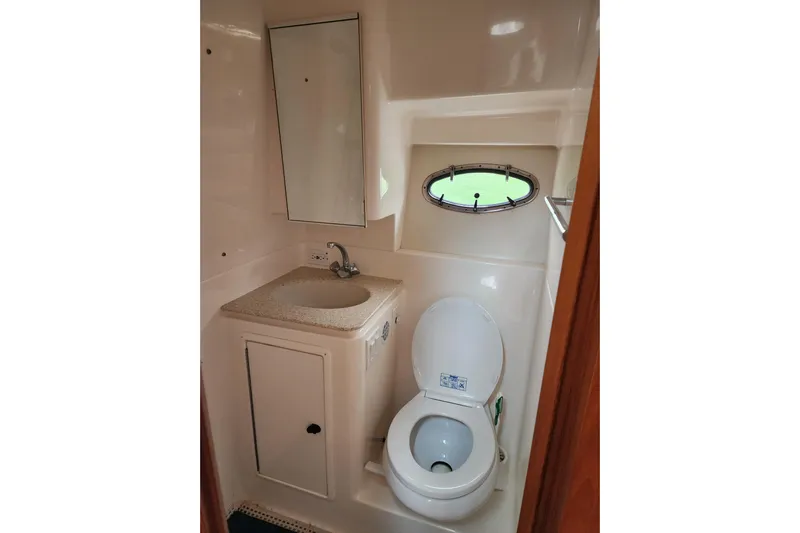  Yacht Photos Pics 2001 Tiara Yachts 3500 Open bathroom with sink, toilet, and porthole window.