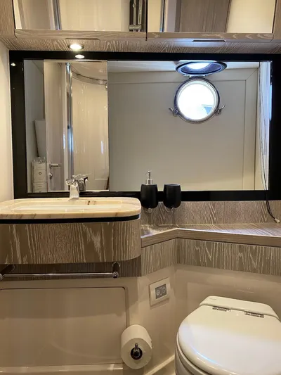 Mizar Yacht Photos Pics Luxurious bathroom in 2017 Azimut Magellano 53 yacht with modern fixtures and porthole window.