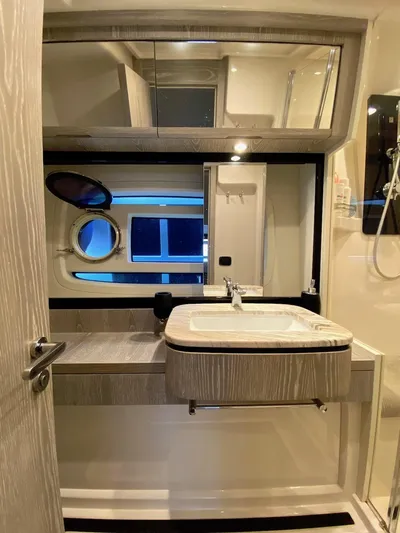 Mizar Yacht Photos Pics Luxurious bathroom in 2017 Azimut Magellano 53 yacht with modern fixtures and porthole window.
